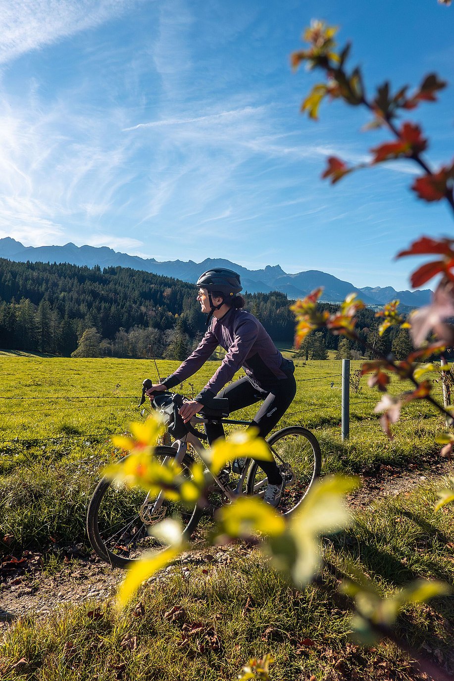 Radfahrerin auf dem Gravelbike vor Alpenpanorama Radfahrerin auf dem Gravelbike vor Alpenpanorama